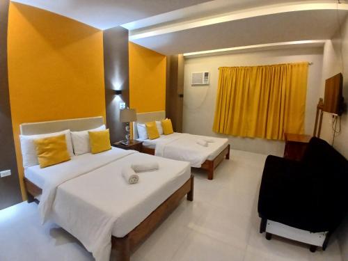 a hotel room with two beds and a chair at Maison De Gloria in Locsin