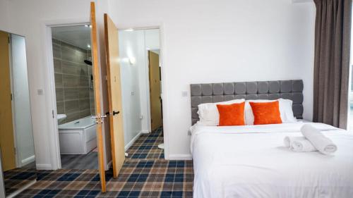 a bedroom with a bed with orange and white pillows at Etihad Coop Arena City Centre Stay in Manchester