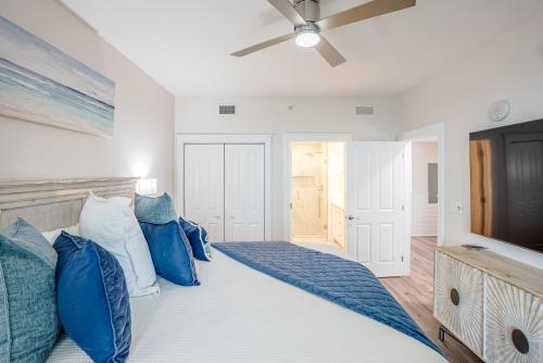 a bedroom with a large bed with blue pillows at Ocean Blue at 1805 Aqua in Panama City Beach