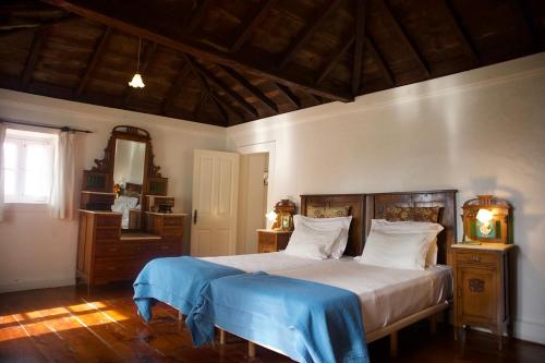a bedroom with a large bed with a blue blanket at Faja dos Padres in Ribeira Brava
