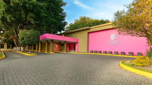a building with a pink and yellow building at Camino Real Guadalajara in Guadalajara