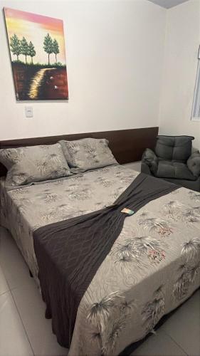a bed in a bedroom with a painting on the wall at Havana Flats - Apto térreo 700m praia - Área Gourmet com 3 churrasqueiras in Balneário Gaivotas