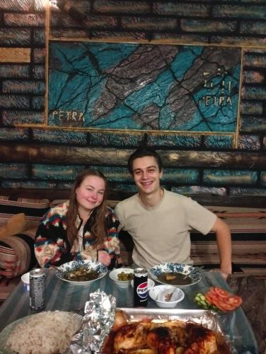 a man and a woman sitting at a table with food at Petra Anas House in Wadi Musa