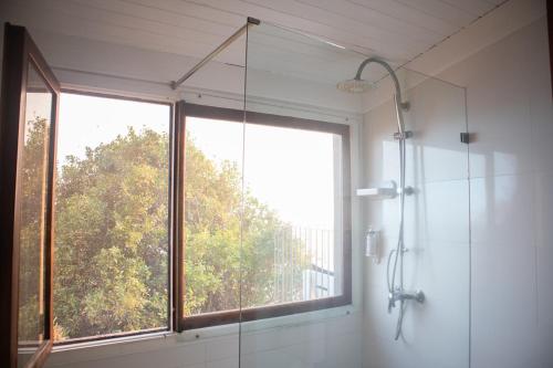 a bathroom with a shower and a large window at Faja dos Padres in Ribeira Brava