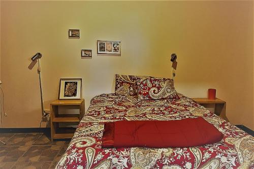 a bedroom with a bed with a red comforter and two lamps at YayazNature Lodge in Grecia
