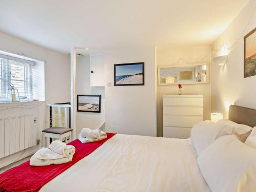 a bedroom with a large white bed with towels on it at 2 Bed in Holt oc-78478 in Blakeney