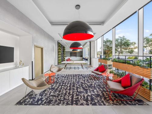 a living room with chairs and a red lamp at ibis Styles Dubai Airport Hotel in Dubai