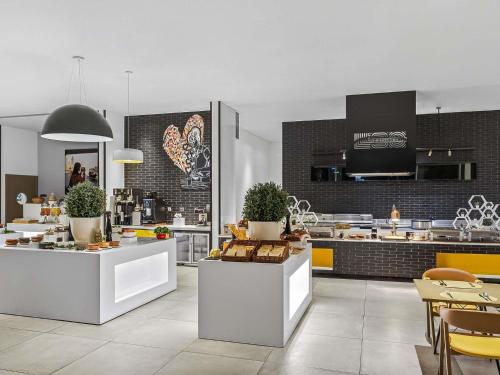 a kitchen with white counters and a large kitchen at ibis Styles Dubai Airport Hotel in Dubai