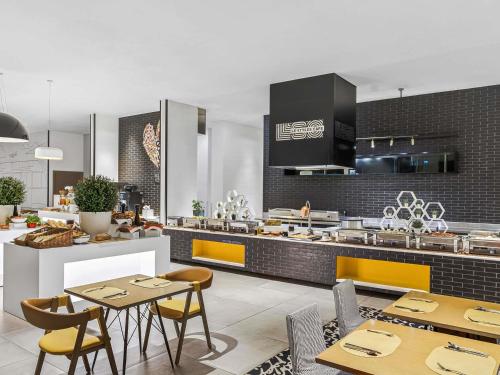 a kitchen with tables and chairs and a counter at ibis Styles Dubai Airport Hotel in Dubai