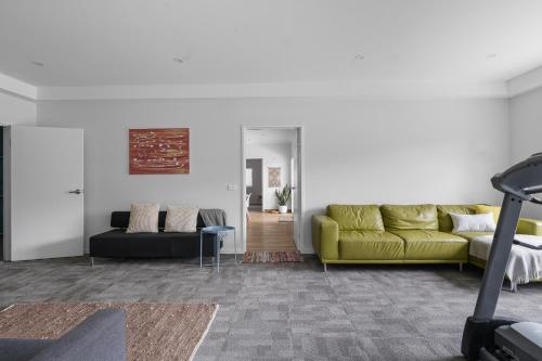 a living room with a yellow couch and a table at Misons Guesthouse in Mollymook
