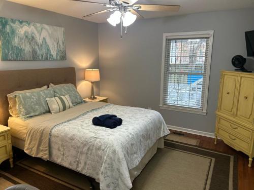 a bedroom with a bed with a hat on it at Under the Oaks, A Downtown Hidden Gem in Wilmington