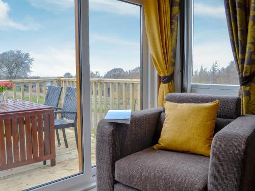 a living room with a couch and a balcony at Skylark Lodge in Westward