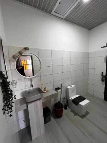a bathroom with a sink and a mirror and a toilet at RESIDENCE MGA HOTEL in Ouidah