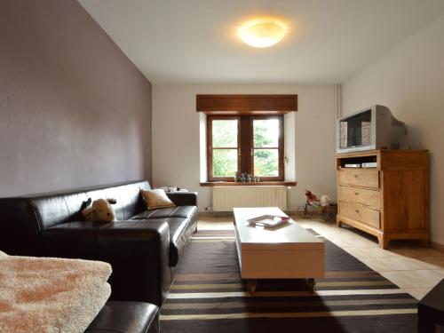 uma sala de estar com um sofá e uma mesa de centro em Cozy Holiday Home in Odeigne with Sauna em Odeigne