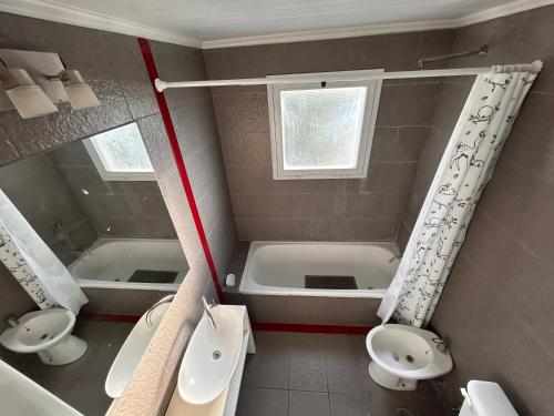 a bathroom with two sinks and a tub and two toilets at Portal del Sol in Junín