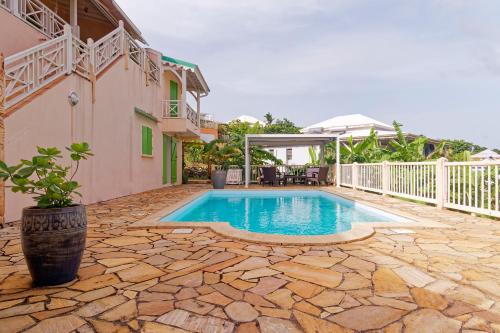 a swimming pool in front of a house at KAZ à STAM in Goyave