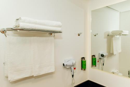 a bathroom with white towels and a mirror at Hotel Monreale Resort in Poços de Caldas