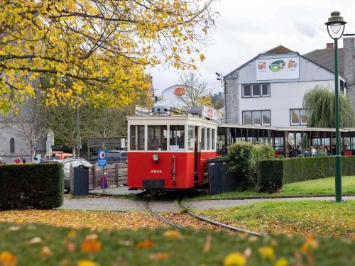 a red and white trolley car on the tracks at Mercure Han-sur-Lesse in Han-sur-Lesse