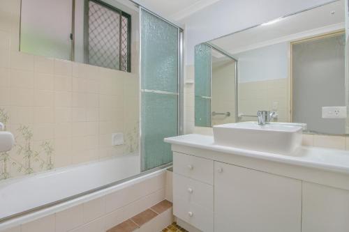 a white bathroom with a sink and a mirror at Kirra Gardens Unit 9 in Gold Coast
