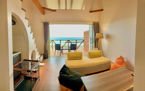 a living room with a bed and a balcony at Love&Peace Resort in Shima