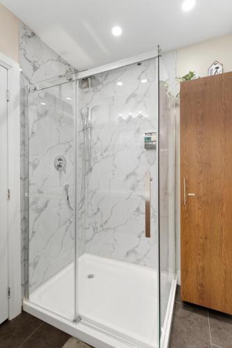 a shower with a glass door in a bathroom at Spruce Suite Historic NOTL - VINEYARD RETREAT in Niagara-on-the-Lake