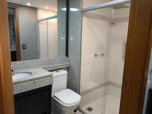 a bathroom with a shower and a toilet and a sink at Flat Palmas Vivence Suítes in Palmas