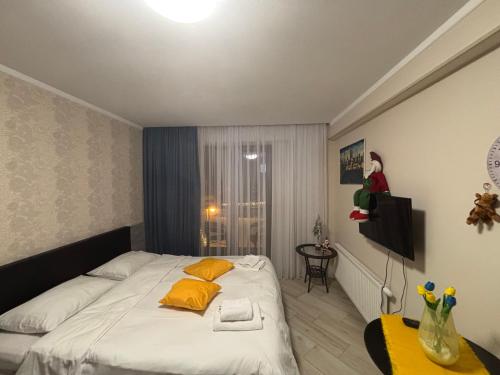 a bedroom with a bed with yellow pillows on it at Orbi Palace Bakuriani in Bakuriani