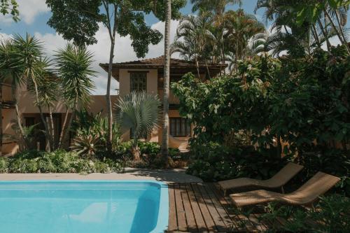 a resort with a swimming pool and a house at Pousada Erva Doce in Arraial d'Ajuda