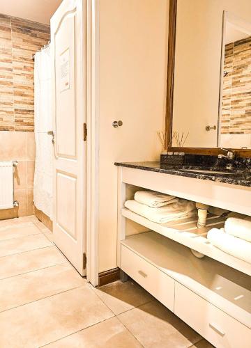a bathroom with a sink and a mirror and towels at Hotel Lunajuim in El Chalten