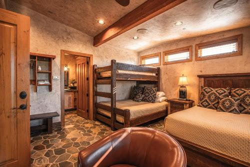 a bedroom with two bunk beds and a chair at Cougar Ridge Resort in Torrey