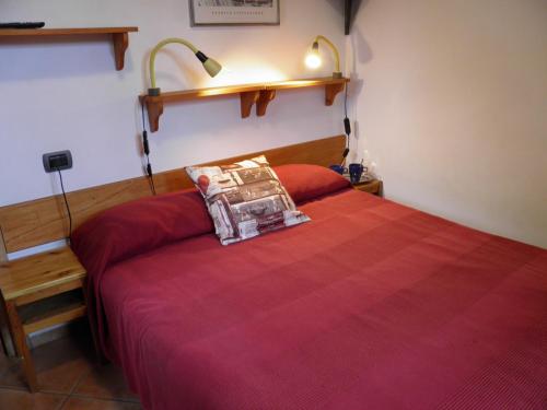 a bedroom with a bed with a red bedspread at Rosato in Gravedona