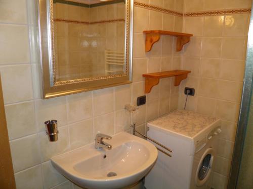 a bathroom with a sink and a washing machine at Rosato in Gravedona