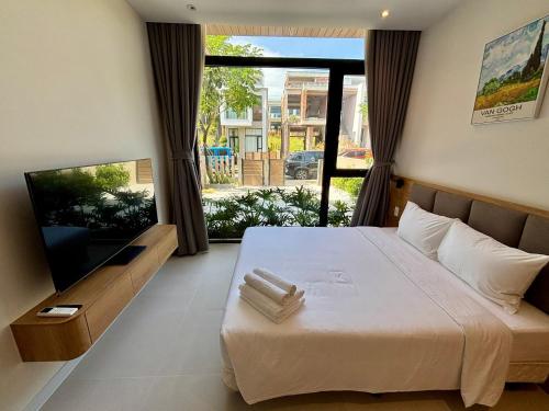 a bedroom with a large bed and a large window at Aurora Golf Villa in Bình Sum