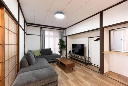 a living room with two couches and a tv at Oyadoya江南名古屋まで車で40分Free car space2台 in Kōnan