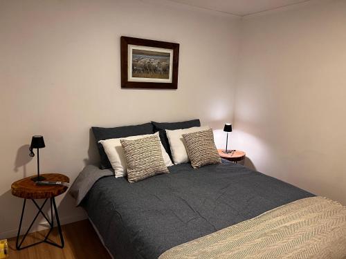 a bedroom with a bed with pillows and a picture on the wall at Magnolia Mini House Casa A in Puerto Natales