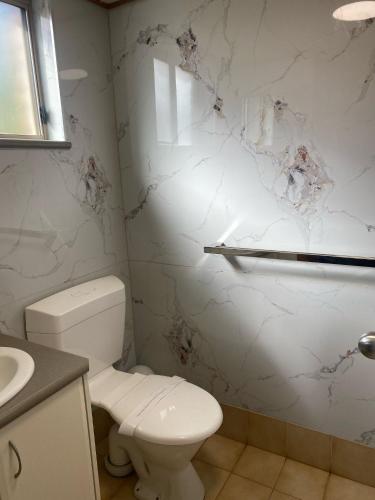 a white bathroom with a toilet and a sink at Darling Junction Motor Inn in Wentworth