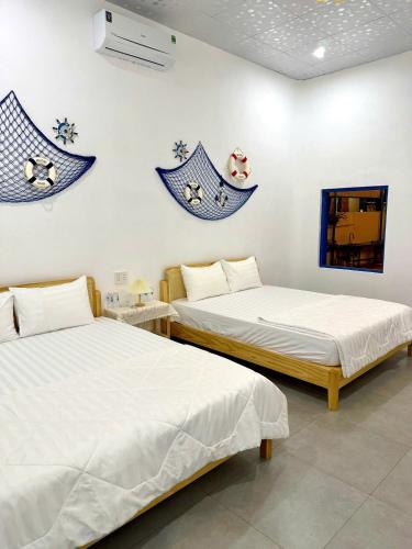two beds in a room with blue decorations on the wall at Homestay Đan Sam in Ninh Hải