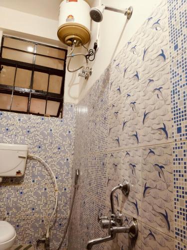 a bathroom with a shower with dolphins on the wall at Tulip - Shillong in Shillong
