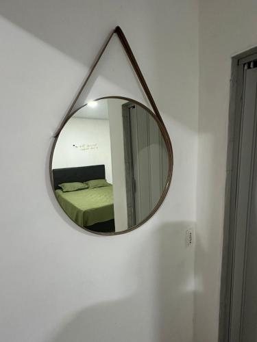 a mirror hanging on a wall in a room at KITNET mobiliada com ar condicionado in Guarujá