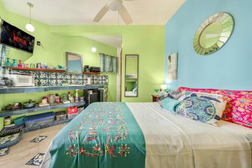 a bedroom with a large bed and a kitchen at Casa Cielo Studio 1 with Tropical Garden Patio in Isla Mujeres