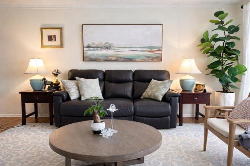 a living room with a black couch and a table at Charming Getaway Make Memories in Sterling Heights