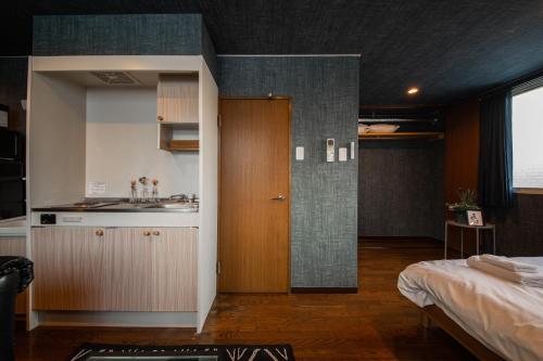 a room with a kitchen and a sink and a bed at Silk Court 202 in Chitose
