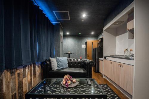 a living room with a leather couch and a table at Silk Court 202 in Chitose