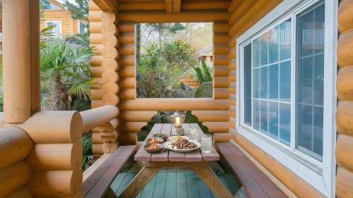 a small table on the porch of a log cabin at Seogwipo Neulbada Pet Pension in Seogwipo