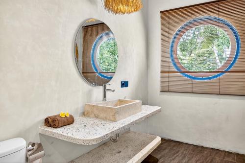 a bathroom with a sink and a mirror at Arch Penida by Bali Cabin in Nusa Penida