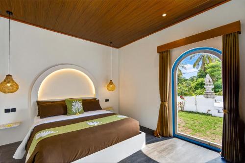 a bedroom with a bed and an arched window at Arch Penida by Bali Cabin in Nusa Penida