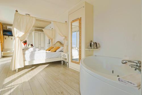 a bathroom with a tub and a bed and a mirror at Relais Villa Olivi in Costermano