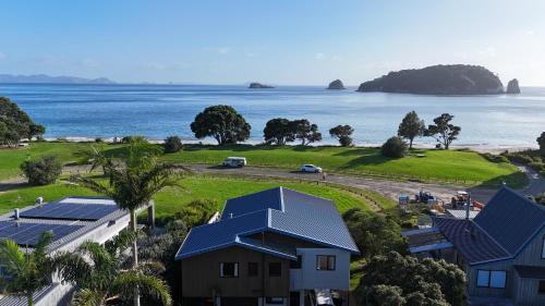 an aerial view of a house and the ocean at Hahei Beachside Escape in Hahei