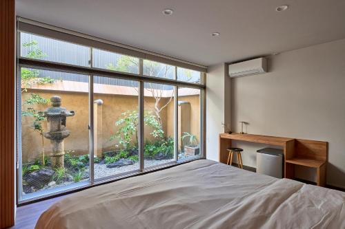 a bedroom with a large window looking out at a garden at Hotel Zen in Kyoto