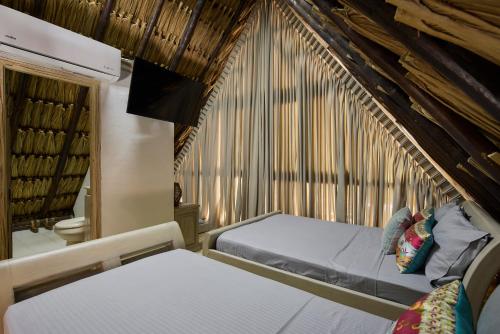 a bedroom with two beds and a large window at Finca Los Mangos in Doradal